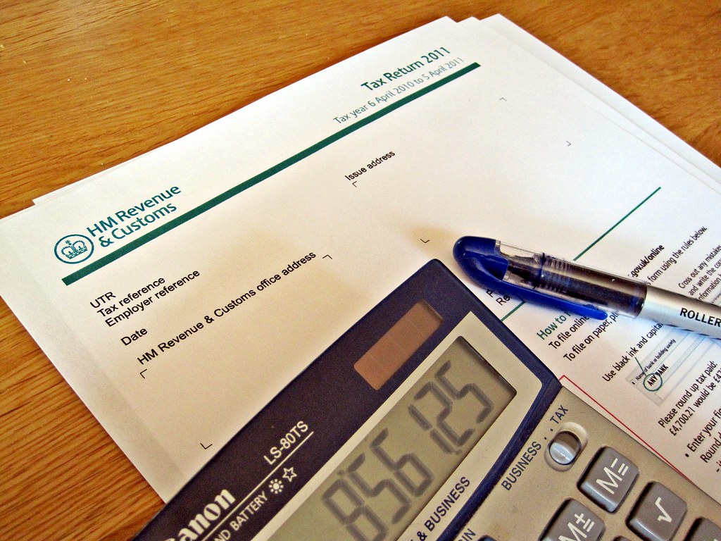 hmrc tax return form with pen and calculator